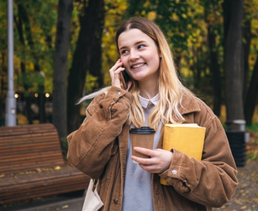 Student on the phone holding coffee